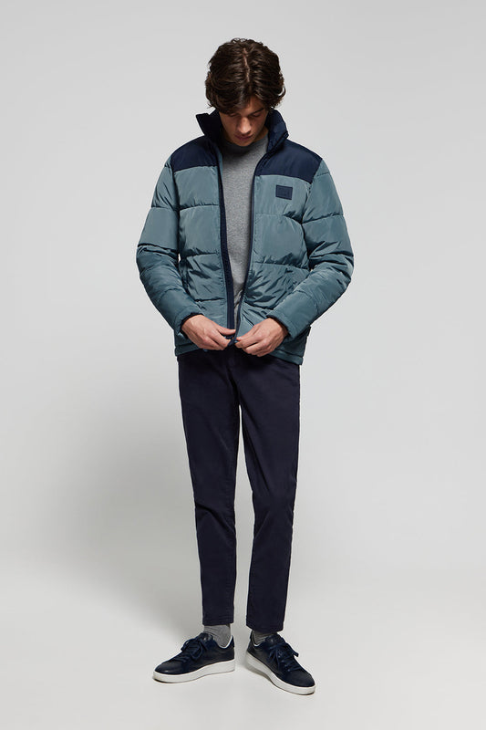 Denim-blue puffer jacket with high collar and logo patch