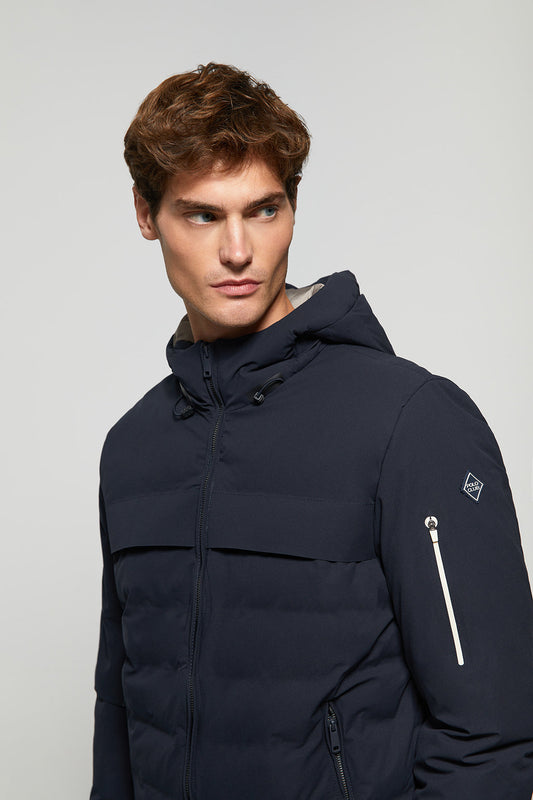 Navy-blue hooded puffer jacket with diamond-shaped patch on sleeve