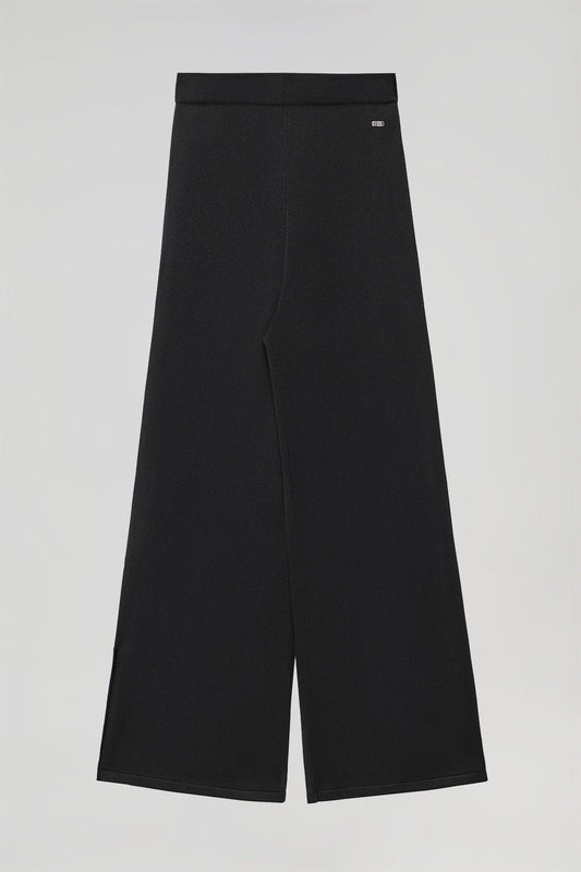 Pantaloni lunghi neri in maglia e particolare di bottone perlato