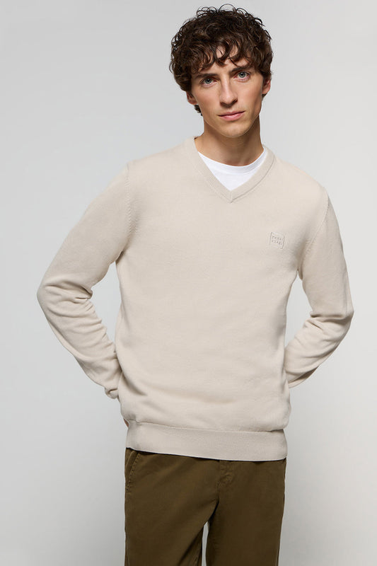 Uniwersalny beżowy sweter z dekoltem w szpic i dopasowanym kolorystycznie, wyszywanym logo