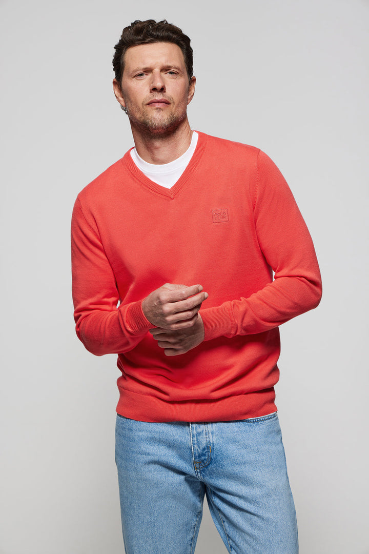 Uniwersalny sweter w kolorze koralowym z dekoltem w szpic i dopasowanym kolorystycznie, wyszywanym logo